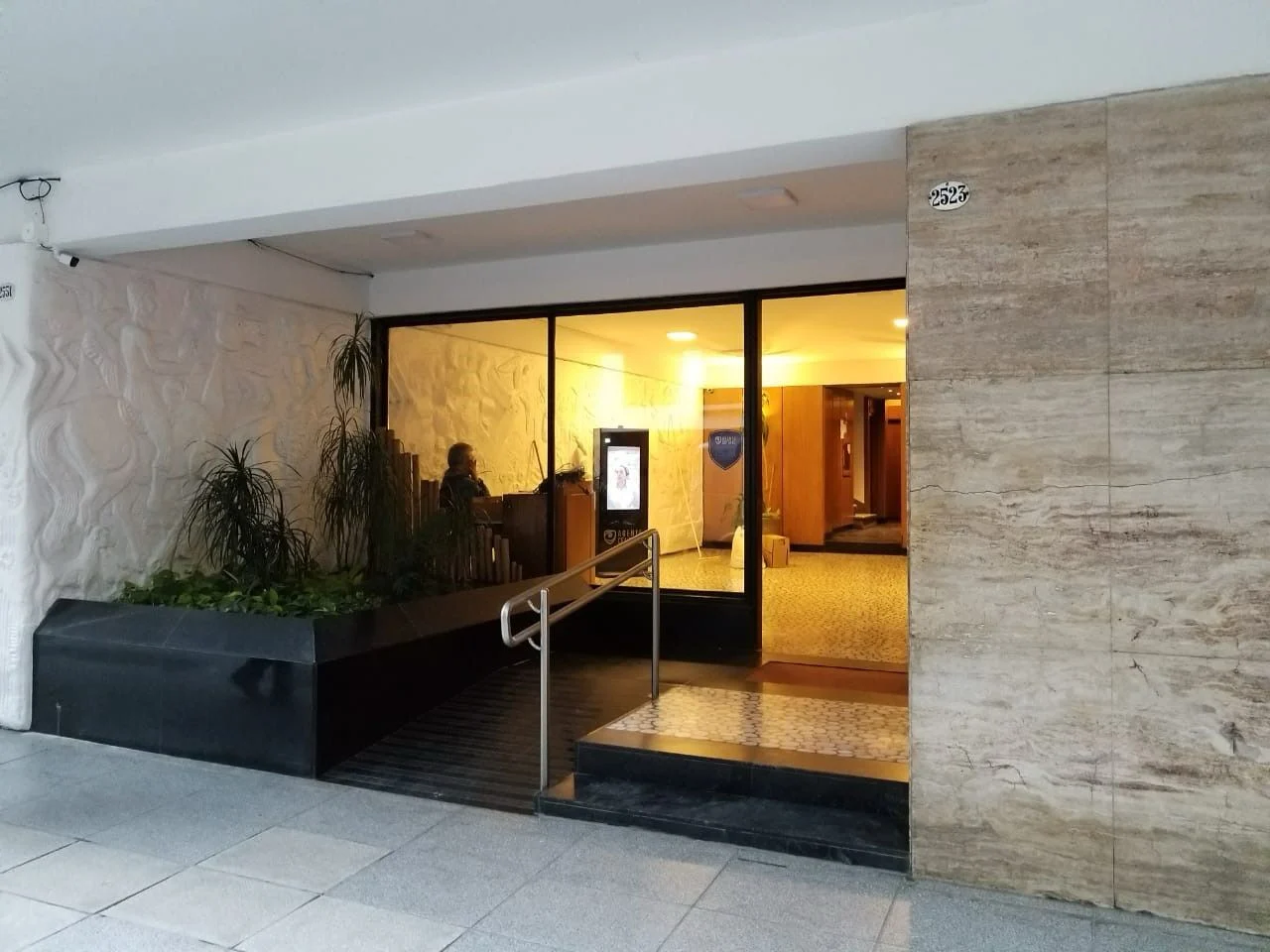 Ingreso de edificio con tótem de seguridad virtual en el hall
